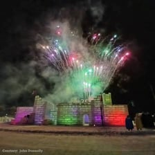 A large palace-like structure made of ice at a winter festival.