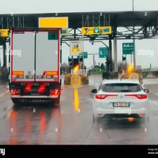 Cars passing through a highway toll booth.