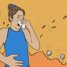 A person sneezing into a tissue.