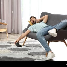 A person playing a video game while seated on a sofa