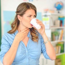 A person discreetly clearing their throat during a conversation.