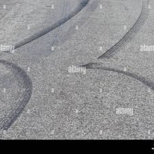 Dark curved tire marks on a paved road