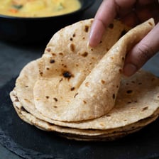 Round Indian roti flatbreads arranged on a plate