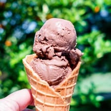 A scoop of ice cream served in a waffle cone.
