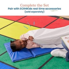 Young children resting on nap mats in a preschool classroom.