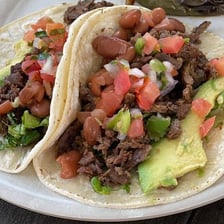 Grilled carne asada served in tacos at a taqueria.