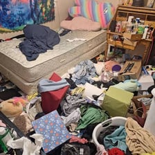 A cluttered bedroom resembling a pigsty.