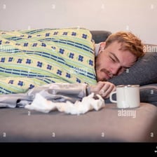 A person resting in bed while feeling ill.