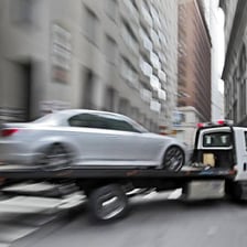 A tow truck lifting a car during a repossession.