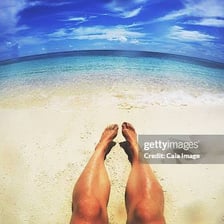 A person relaxing in direct sunlight on a beach