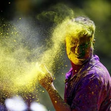 People celebrating Holi by throwing brightly colored powder