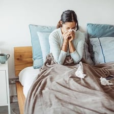 A person resting in bed while recovering from an illness