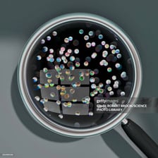 A magnifying glass showing tiny particles to represent very small bits