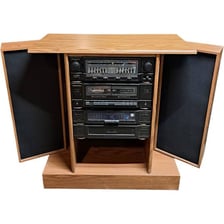 A stereo cabinet with visible speaker grilles on its front panels.