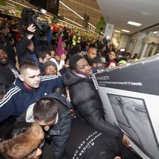 Large crowds of shoppers in a store during a Black Friday sale.