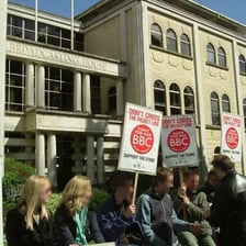Striking workers standing along a picket line.