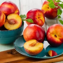 Several ripe nectarines displayed in a fruit bowl.