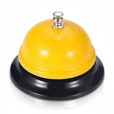 A small service bell sitting on a reception desk.