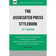 A newsroom editor consulting a style guide.