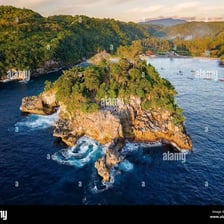 A small rocky island standing alone in surrounding water.