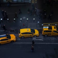 A taxi driving on a city street.