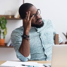 An exhausted person resting at a desk