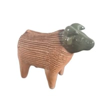A Chia Pet planter covered with green sprouts.