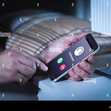 A smartphone showing an incoming call in a dark bedroom.