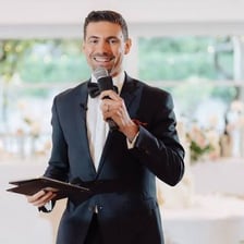 A master of ceremonies hosting an event with a microphone.