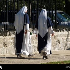A nun in a religious habit doing physical exercise