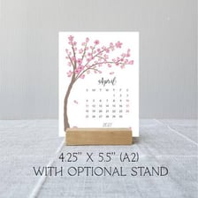 An April calendar page beside spring trees