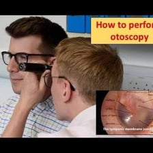 A clinician examining a patient’s ear with an otoscope