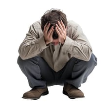 A person sitting alone with a discouraged expression.
