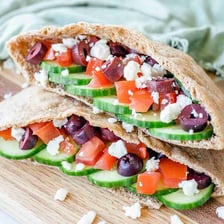 A round pita bread opened to show its hollow pocket.