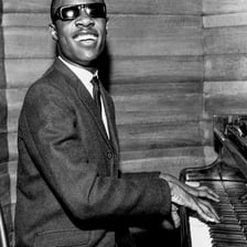 Stevie Wonder performing music at a piano