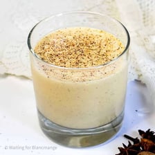 A glass of eggnog topped with nutmeg.