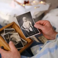 A person looking at old photographs while remembering the past