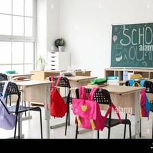 A classroom containing student desks and a board at the front.