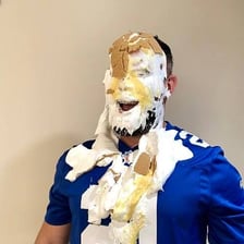 A person gets a pie splashed across their face in a slapstick gag.
