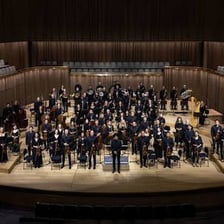 A symphony orchestra performing on a concert stage.