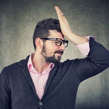 A person reacting with embarrassment after realizing a mistake.