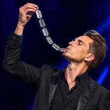 A performer presenting a completed trick with a revealing gesture