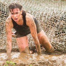 A person walking laboriously through muddy ground.