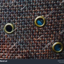 Small reinforced eyelets arranged along the edge of fabric