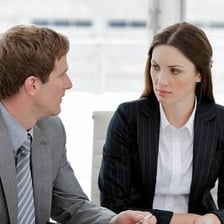 One person sternly reprimands another during a conversation.