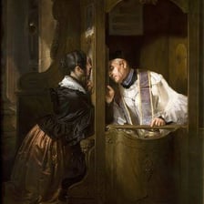 A person speaks with a priest through a confessional screen.