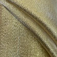 A close-up view of shiny gold lamé fabric.