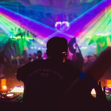 A DJ performing electronic dance music in a nightclub.