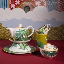 A porcelain tea set arranged with a teapot, cups, and saucers.