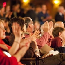 An audience applauding a performer.